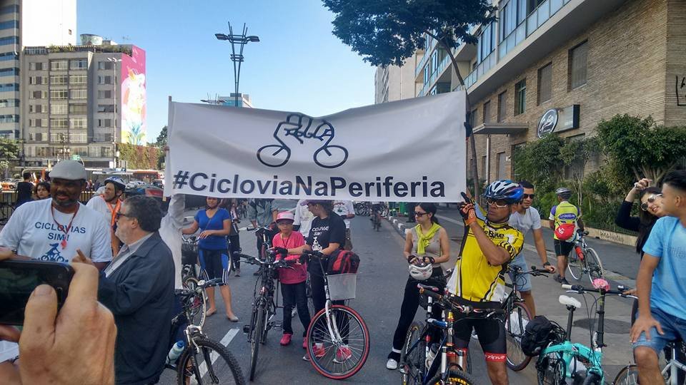 À esquerda, Roberson Miguel, o cicloativista @biosbug, porta orgulhoso a camisa "Ciclovias sim" e acompanha a faixa "#CicloviaNaPeriferia"