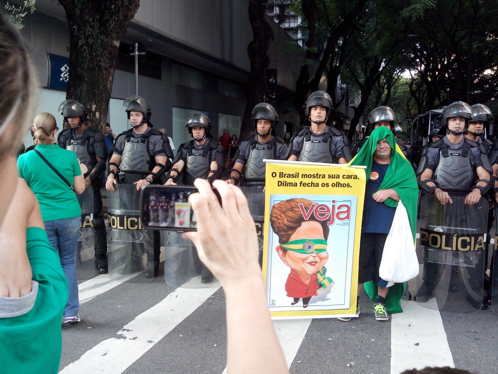 Manifestante com carta da revista Veja se posta diante da Tropa de Choque da PM no dia 12 de abril - Foto: Eduardo Nunomura
