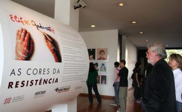 A cara da MPB Elifas Andreato diante de totem de exposição sobre sua obra, em 2010. Foram expostos mais de 100 trabalhos seus, entre cartazes e capas de discos. Acervo Memorial da Resistência de São Paulo. Reprodução