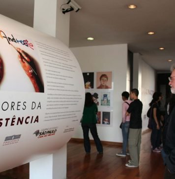 A cara da MPB Elifas Andreato diante de totem de exposição sobre sua obra, em 2010. Foram expostos mais de 100 trabalhos seus, entre cartazes e capas de discos. Acervo Memorial da Resistência de São Paulo. Reprodução