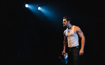 ‘Tráfico’, a sinfonia agridoce da exclusão O ator Robson Torinni encena o monólogo "Tráfico", em cartaz em São Paulo> Ele está vestido com uma camiseta brancas sem mangas e tem um olhar distante com uma luz cortante sobre sua cabeça.